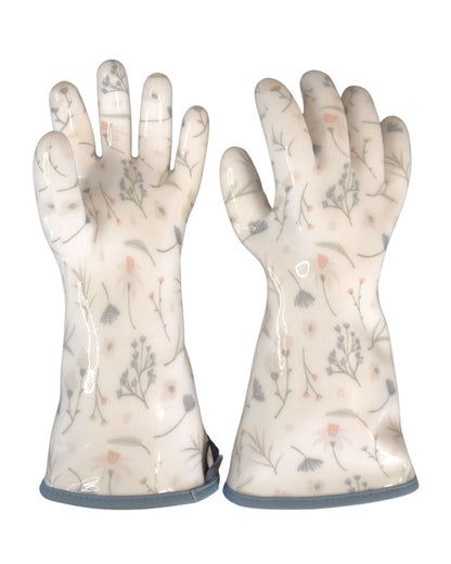 Close-up of the Blue Meadow print and blue wrapped edge, the pair of oven gloves laid flat