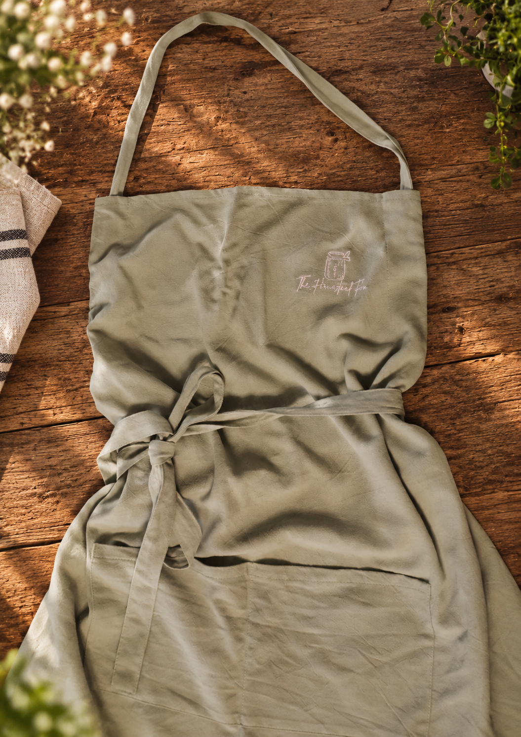 Sage apron worn in a kitchen setting